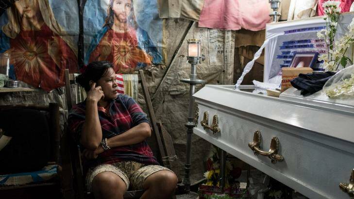 Kimberly Sailog watches over the coffin of her daughter, Christine Joy Sailog, 12, who was killed when an unidentified gunman shot at an alleged drug suspect, hitting the girl during the traditional Christmas dawn mass in a church. Photo: Dondi Tawatao/Getty Images