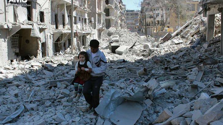 A man and girl amid the rubble of houses destroyed in 2014 by Syrian government air strikes in the city of Aleppo. Every blow to Islamic State in Syria strengthens the Assad regime. Photo: Uncredited