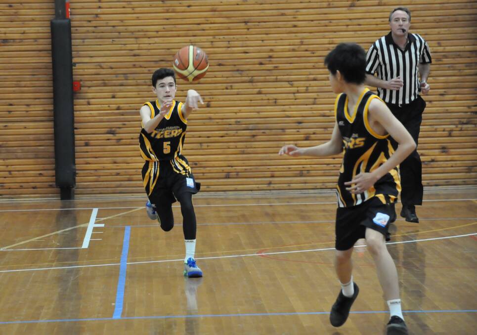 BULLET: Seb Jeffrey passes the ball down court to his team mate Daniel Xiao. Photo: COURTNEY WARD