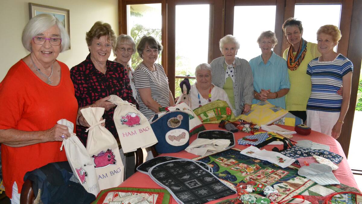 A STITCH IN TIME: Members of the Gerringong committee of the Children’s Medical Research Institute (from left) Edith Burgess, Mena Sharpe, Joyce Sharpe, Barbara Donald, Margaret Weir, Marjorie Wymer, Dawn Miller, Wendy Saxton and Sue Dmetreson and some of the items that will be on sale at the annual Gerringong Quilt Show on November 7-9.