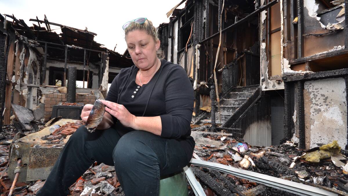 HARD TIMES: Allison Hokin in the wreckage of her parents’ West Nowra home.