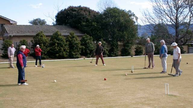 LINE UP: Nowra Croquet Club members and visitors waiting their turn for a shot. 
