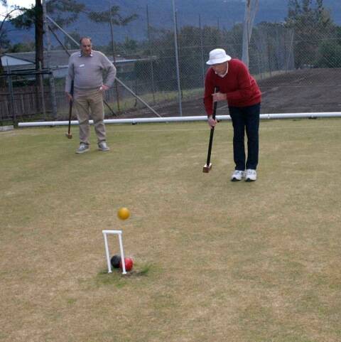 JUMPY: Nowra Croquet Club member Phil Pickard demonstrates a jump for visitor Bill Ralph.