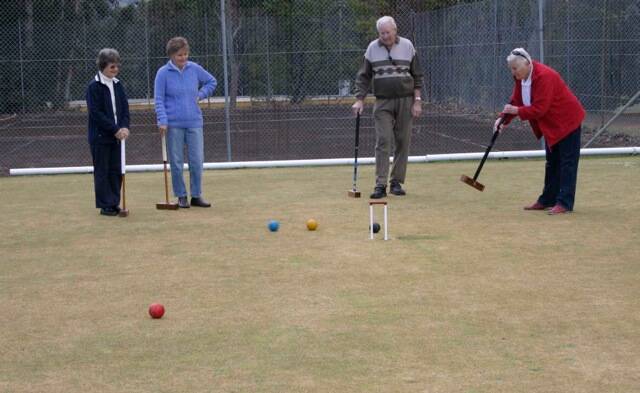 LET’S PLAY: Nowra Croquet Club member Gail Williamson demonstrates to visitors Jenny Dawson, Marie Groenestein and David Dawson how to play croquet.