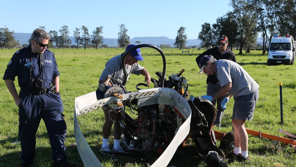 ASRA investigators Alan Wardill (left) and Murray Barker look over the crashed gyrocopter with local instructor Dean Thompson and Forensic Services officer Senior Constable Jeff McInnes.