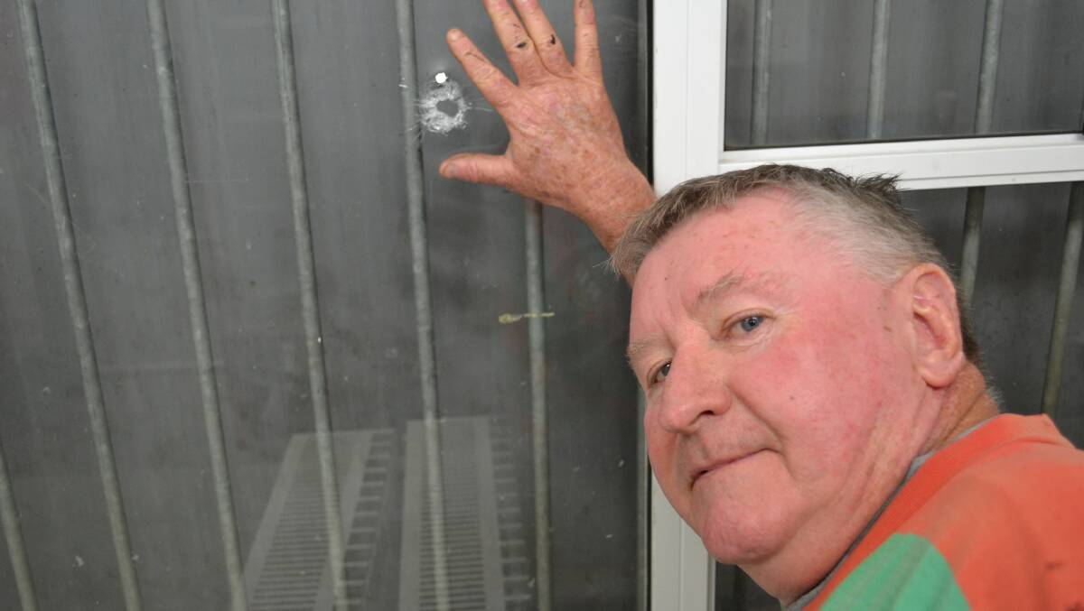 Shoalhaven District Football Association president Ian Cockburn shows the bullet hole in the clubhouse canteen.