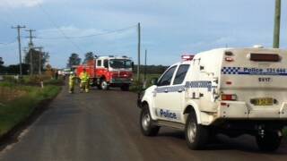 Police and RFS crews on Greenwell Point Road, which is blocked after powerlines came down. 