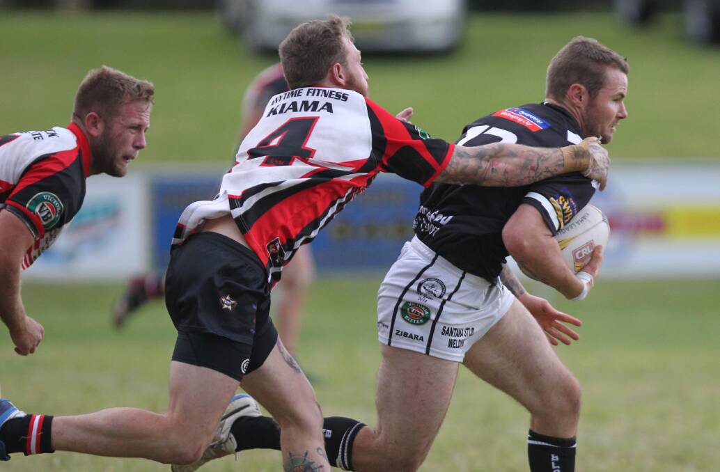 NOTHING IN IT: Port Kembla’s Kaine Edwards tries to break away from Kiama defender James Brown during Sunday’s exciting 16-all draw at Noel Mulligan Oval. Photo: DAVID HALL  