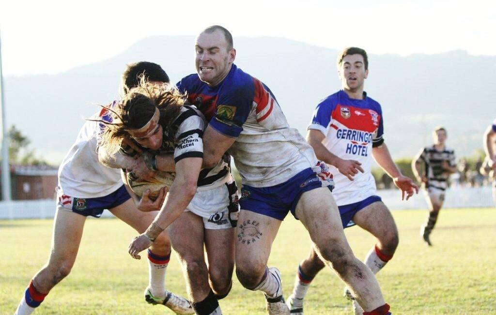 WRAPPED UP: Berry Magpies winger Rory McCall is wrapped up by the Gerringong Lions defence during their 64-4 shellacking at Michael Cronin Oval last week. Photo: PAUL DAVIDSON  
