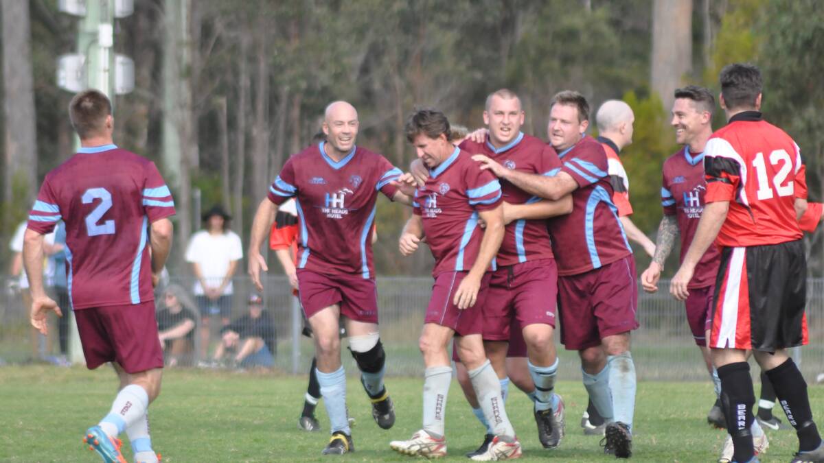 MAN OF THE MOMENT: Dave Crapp is congratulated by his Shoalhaven Heads team mates after scoring the penalty that saw them home for a 1-nil win over United.  