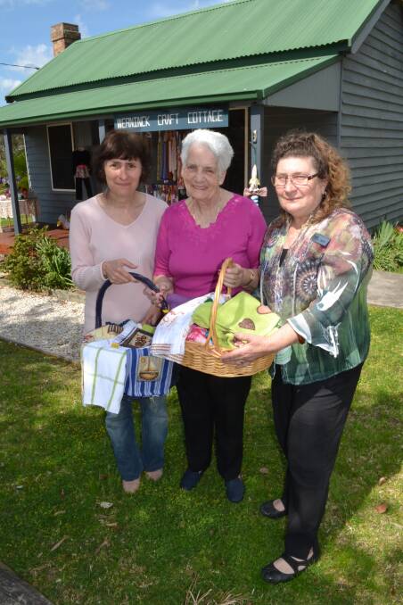 Tanja Honner and Kaye Armstrong from Werninck Craft Cottage present Shoalhaven Hospital Women’s Auxiliary president Pat Glasby (centre) with baskets of handmade goodies for the auxiliary’s November fund-raising stall.