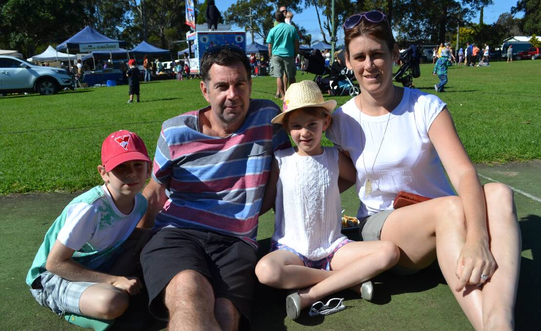 Liam, Paddy, Neve and Sarah Wallington from Sydney relax on the lawn at the White Sands Easter Festival at Huskisson on Saturday. 