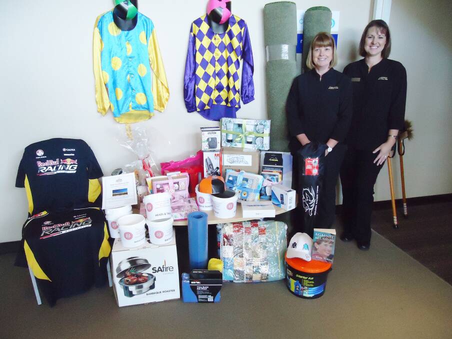 Bomaderry Bowling Club staff and Melbourne Cup committee members Michelle Flanagan and Trudi Stintmann look at the raffle prizes on offer at the Melbourne Cup Charity Luncheon. 
