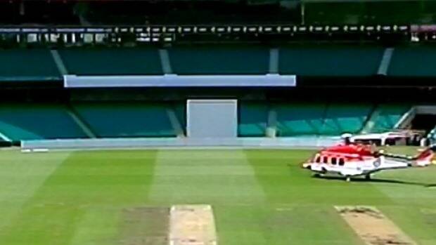 A chopper arrives on the SCG with a doctor to help Hughes.