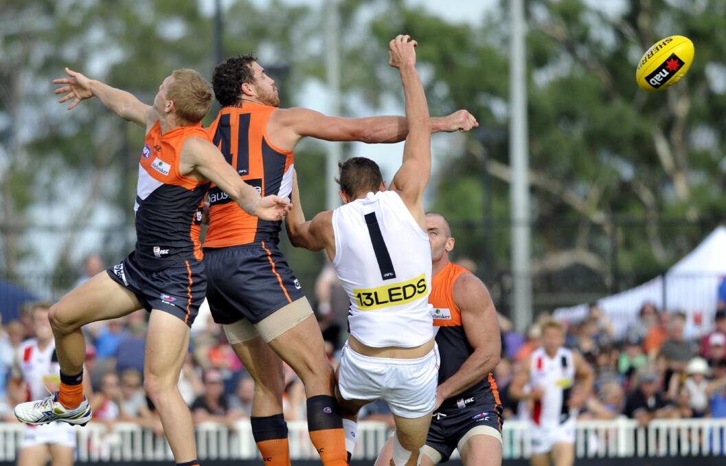 AFL: Giants' Shane Mumford and Adam Treloar and St Kilda's Tom Hickey attempts a mark. Picture: Les Smith