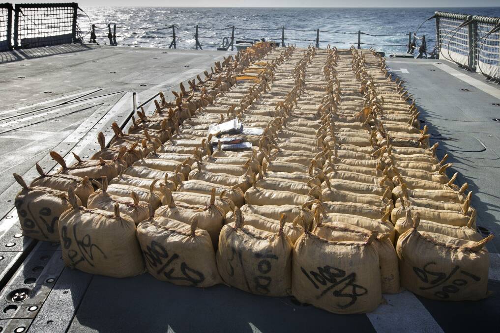 BIG LOAD: Over six tons of hashish seized during a recent boarding placed on the flight deck of HMAS Darwin, prior to destruction. The hashish was contained in 306 hessian bags each containing approximately 20 kilogram coffee bags, a sample of which can be seen on top. 	Photo: SARAH WILLIAMS