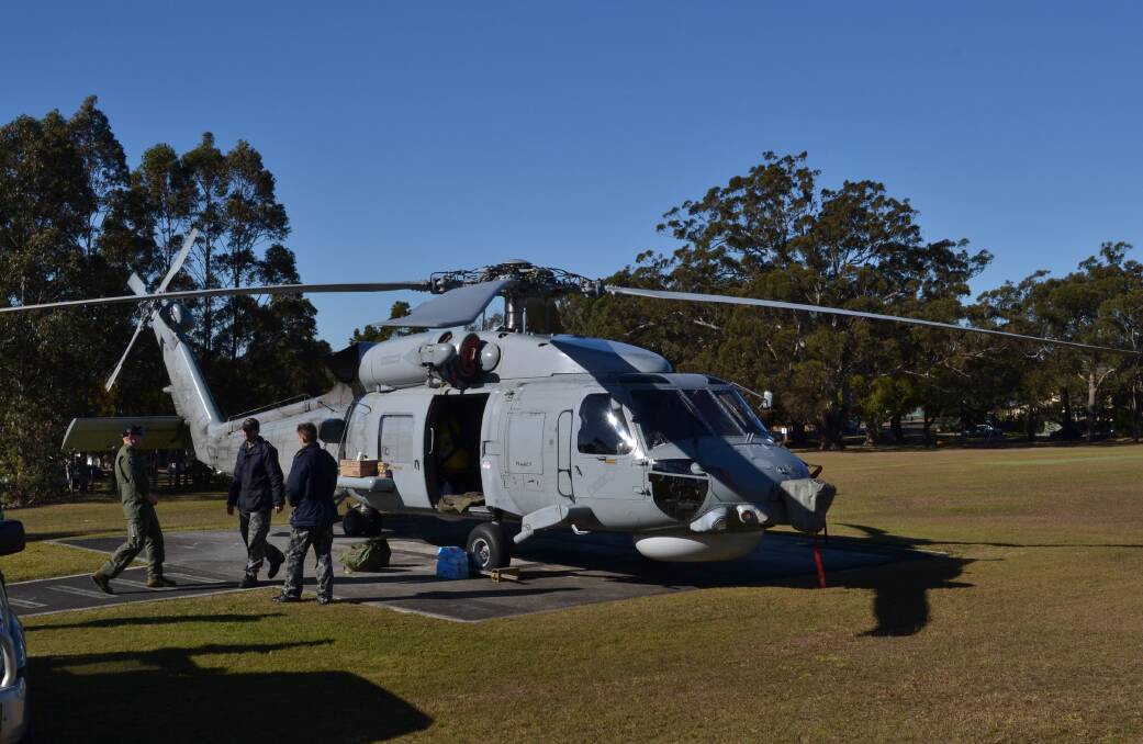 SAFETY FIRST: Maintenance crews from HMAS Albatross work to fix an engine problem with a Seahawk helicopter from 816 Squadron, on the helipad of Shoalhaven Hospital.