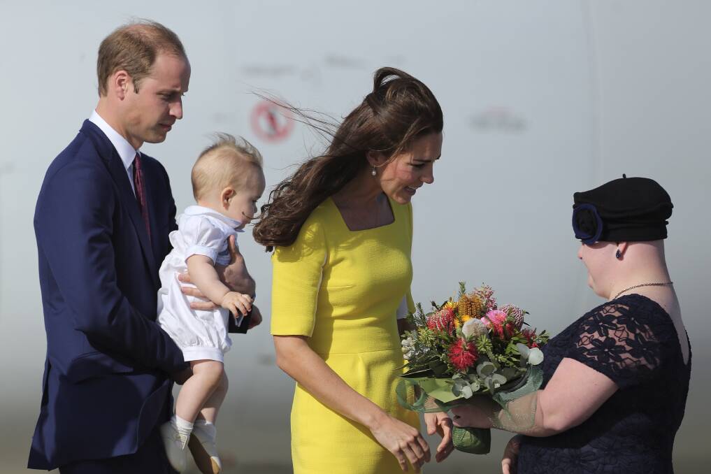 Rare moment: Her Royal Highness, Catherine Duchess of Cambridge receives flowers from Joscelyn Sweeney, with His Royal Highness Prince William, Duke of Cambridge holding Prince George on arriving at Sydney Airport. Photo: KATE GERAGHTY