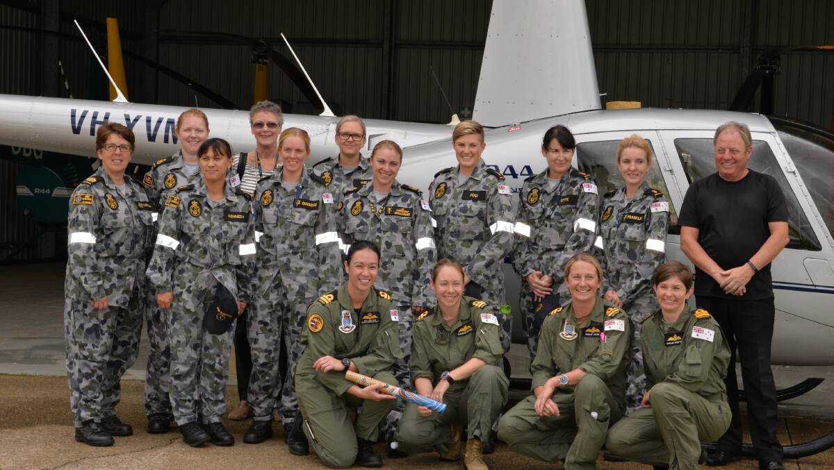 HMAS Albatross’ female pilots, in green, Lieutenant Sally-Anne Malone, Lieutenant Tammielee Moffatt, Lieutenant Natalie Davies and Lieutenant Commander Natalee Johnston with the baton for the first Women Pilots’ Relay of Flight on Wednesday, raising money for Cancer Council and promoting women in aviation with passengers both military and civil along for the ride to Bankstown, Sydney.
