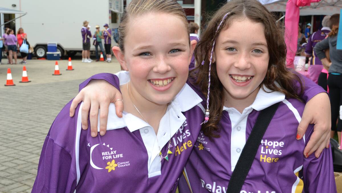 Amy Whelan and Emma Falls from Cambewarra walk their Relay For Life laps together at the Shoalhaven Entertainment Centre on Saturday.