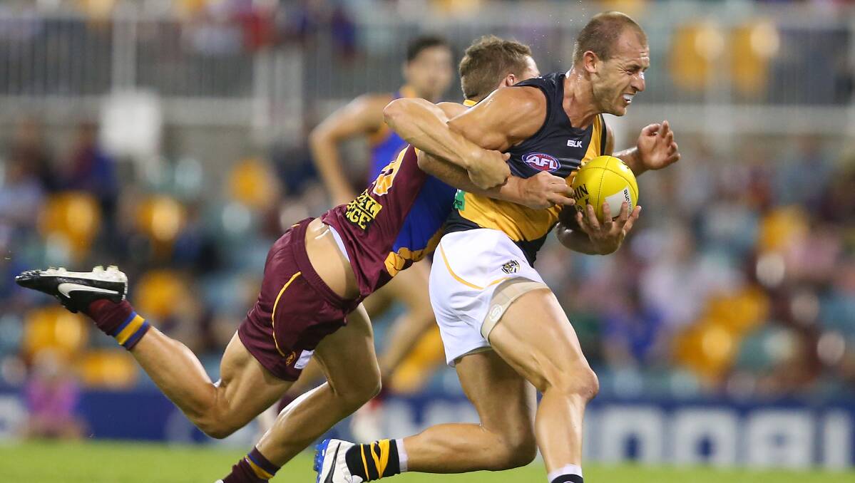 Jack Redden of the Lions tackles Matt Thomas of the Tigers during the round five AFL match between the Brisbane Lions and the Richmond Tigers at The Gabba on April 17, 2014 in Brisbane, Australia. Photo: Chris Hyde/Getty Images.