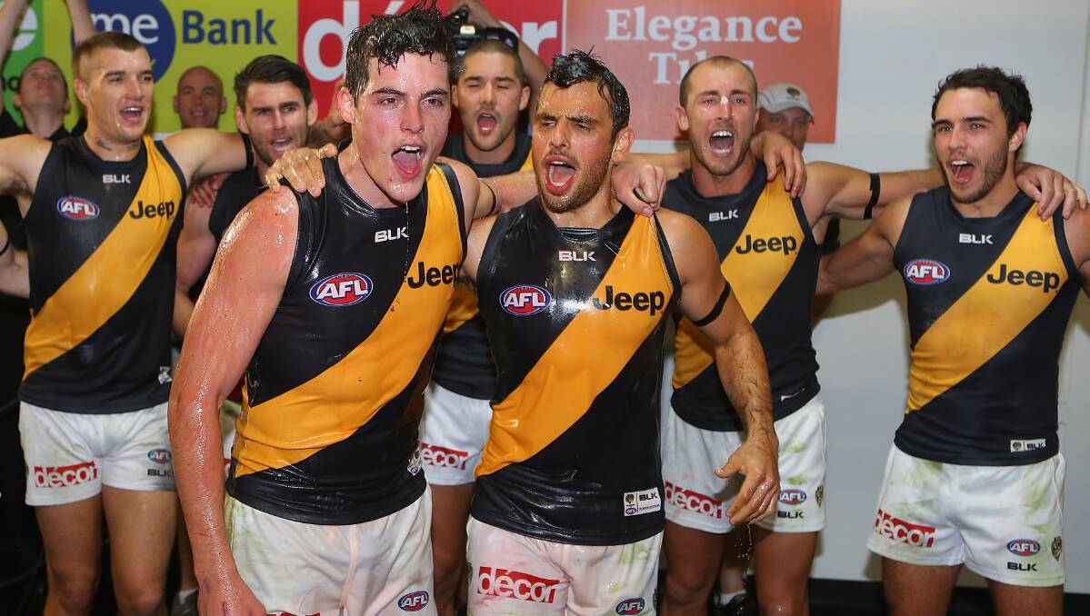 Nathan Gordon and Sam Lloyd of the Tigers sing the team song after winning the round five AFL match between the Brisbane Lions and the Richmond Tigers at The Gabba on April 17, 2014 in Brisbane, Australia. Photo: Chris Hyde/Getty Images.