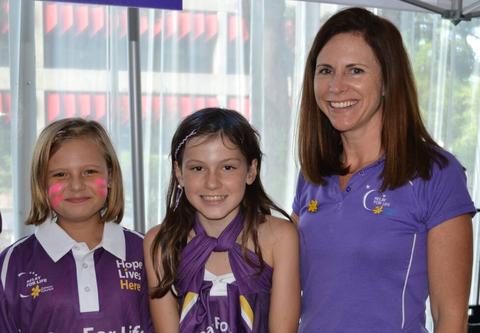 HELPING: Teagan Hunt, Mercedes Woolley help Tammy Johnston from the Cancer Council as much as they can at the Relay For Life at the Shoalhaven Entertainment Centre on Saturday.