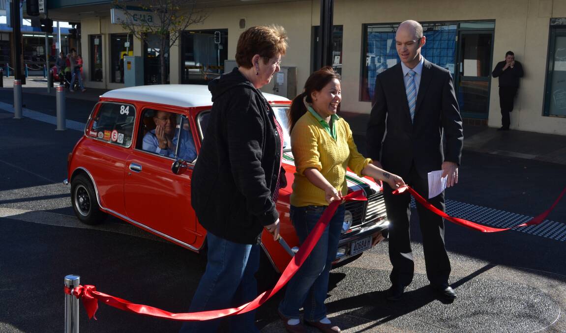 OFFCIAL: Shoalhaven City Council director of assets works Ben Stewart invited business owners Anne Snow from Anne’s Second Hand Book Shop and Deb Trinh from Nowra Village Hot Bake to cut the red ribbon and declare Junction Court open to traffic as excited motoring enthusiast Wayne Brighton readied his red mini to be the first car to drive on the surface on Saturday morning.