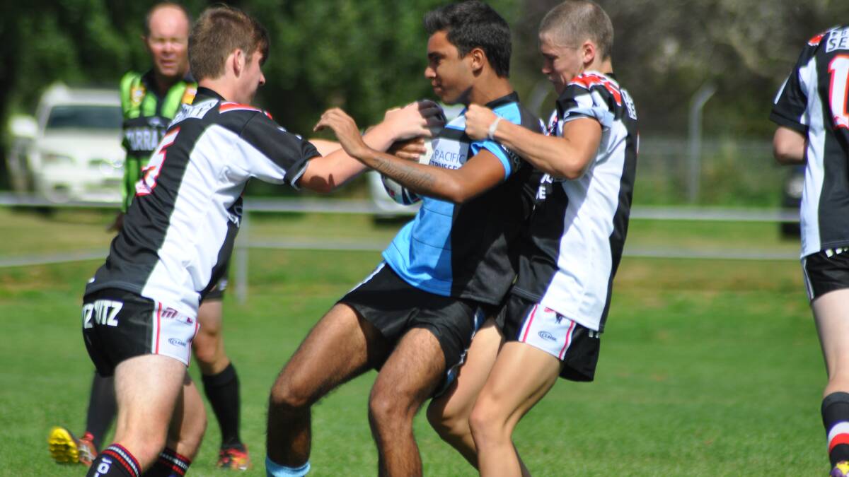 STALLIONS SWAMP: Moruya’s Ray Kelly tries to break a two-man tackle on Saturday. 
