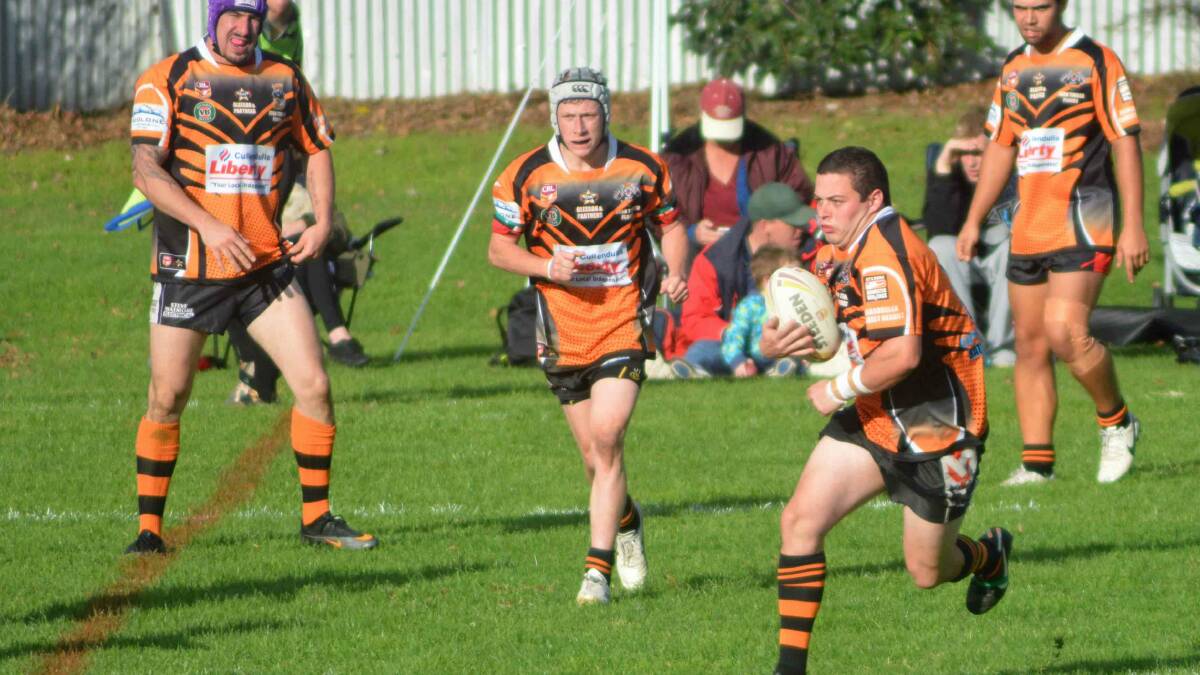 TIGER TOUGH: Michael Sinclair, Ben Carmody and Dylan Powell look on as Scott Belcher takes a hit up against Bega. 
