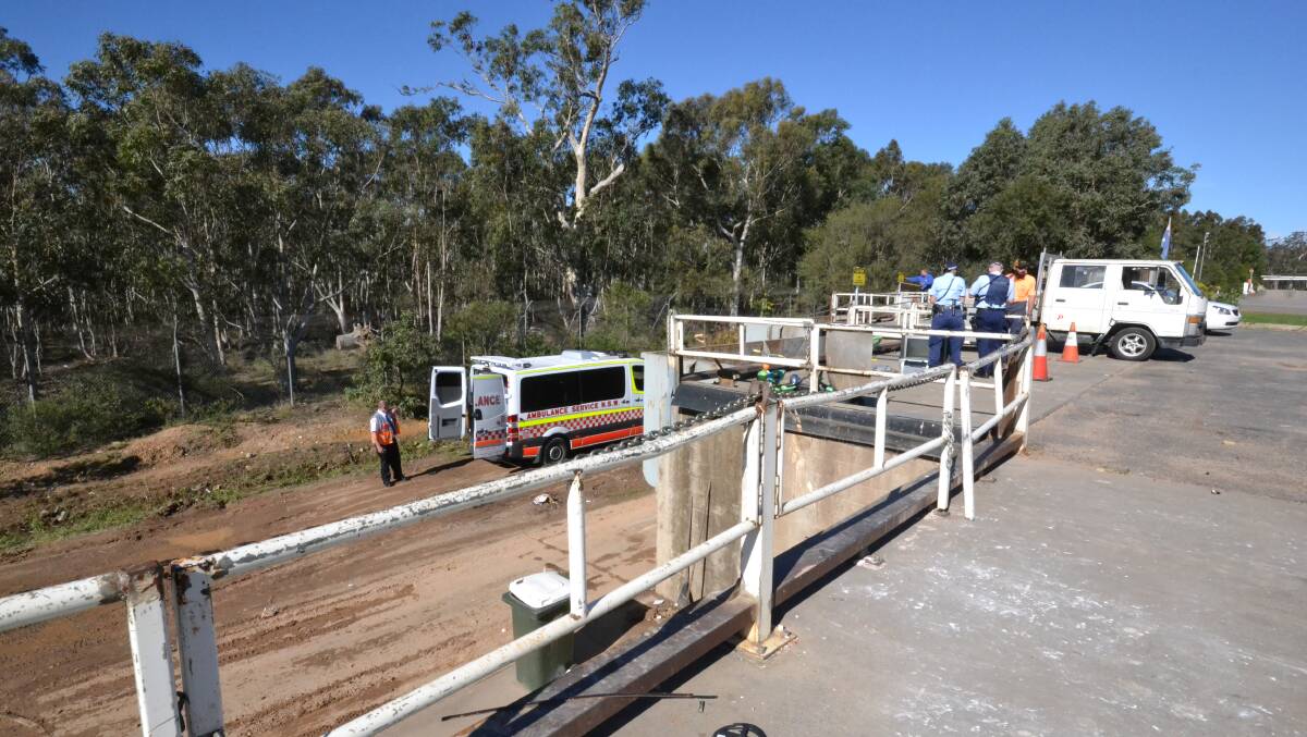 Ambulance paramedics and police officers at the West Nowra waste depot, where a man was critically injured after falling into a skip.