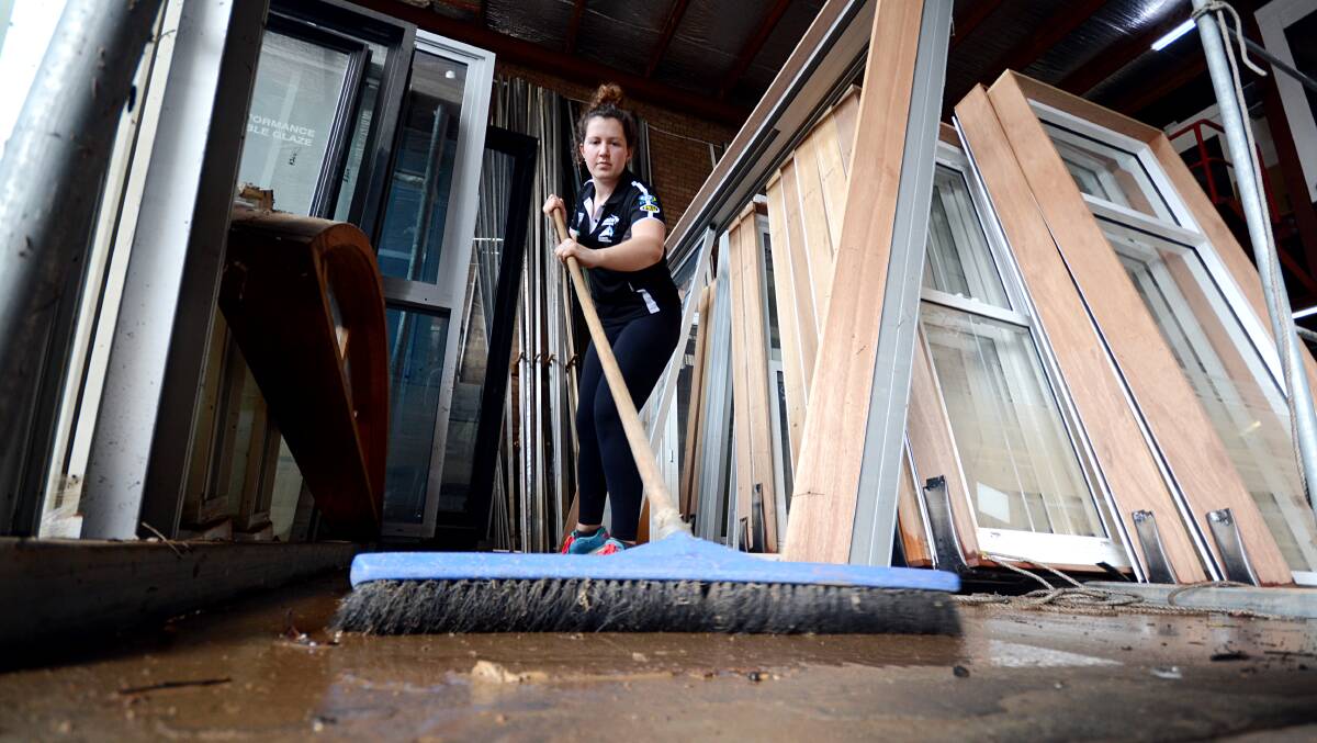 CLEAN-UP: Rebecca Hanlon helps clean mud out of the family business in Bomaderry.