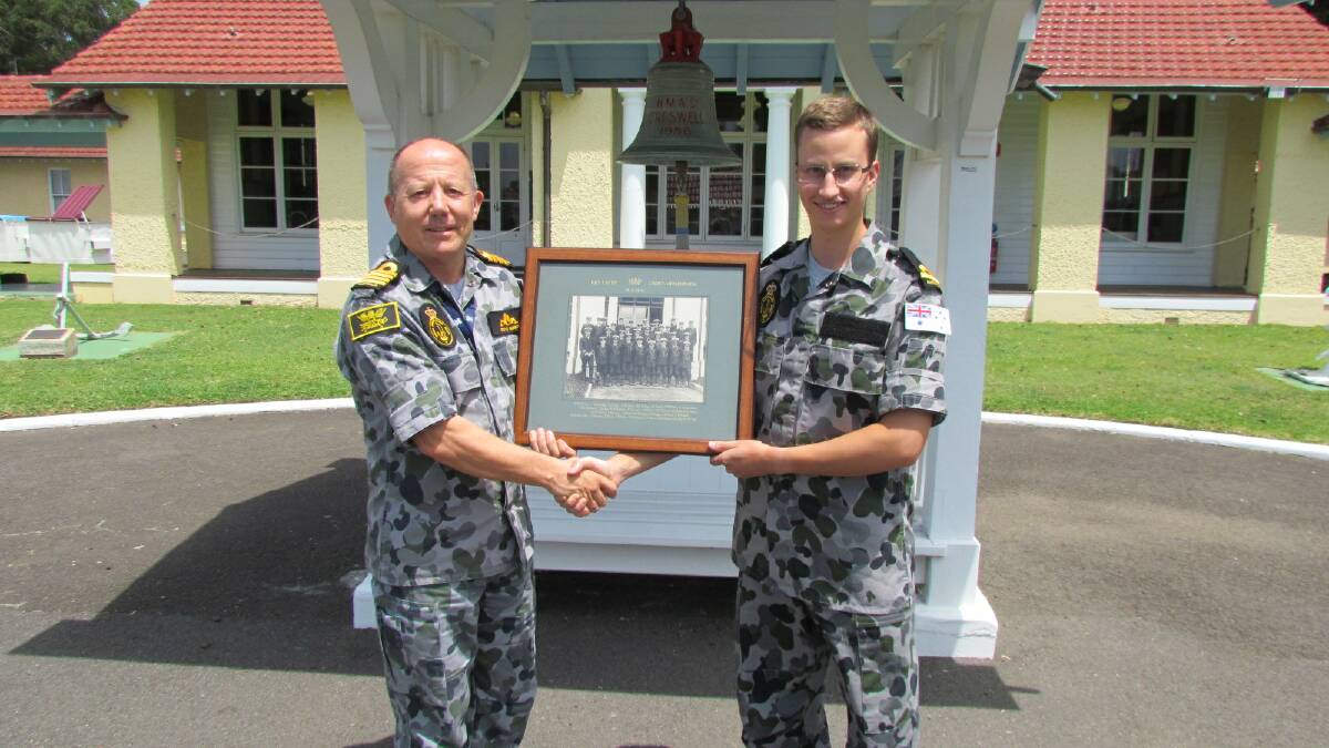 HISTORY CLASS: HMAS Creswell commanding officer Captain Stephen Hussey presents Sub Lieutenant Nicholas Guireff with a signed photograph of the 1915 entry cadet midshipmen, of which his great great uncle, Midshipman John Abbott was part on the very spot where the photo was taken 100 years ago. 