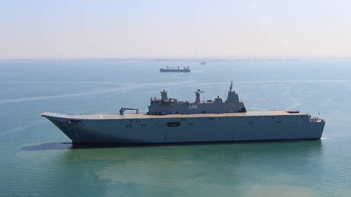 GIANTS: Canberra, the navy’s newest and largest ship, arrives in Jervis Bay dwarfed by Point Perpendicular.