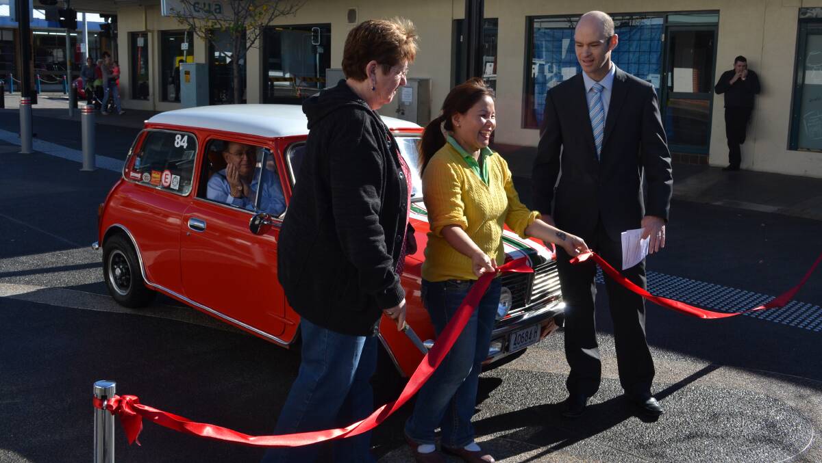 OFFICIAL: Shoalhaven City Council director of assets works Ben Stewart invited business owners Anne Snow from Anne’s Second Hand Book Shop and Deb Trink from Nowra Village Hot Bake to cut the red ribbon and declare Junction Court open to traffic on Saturday morning. Excited motoring enthusiast Wayne Brighton readied his red mini to be the first car to drive on the surface.