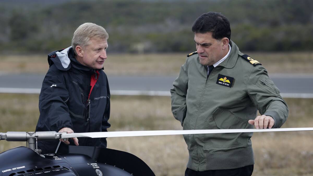 EYE IN THE SKY: Hans Schiebel explains the workings of the Schiebel S-100 Camcopter Unmanned Air System to Commander Fleet Air Arm, Commodore Vince Di Petro, at the Jervis Bay Airfield. Photo: JAYSON TUFREY