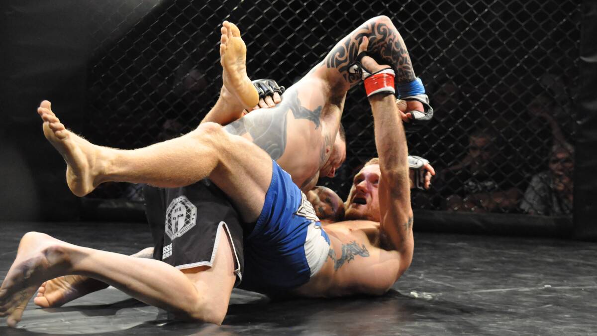 DOWN: Shoalhaven’s Craig Martin lays a punch into Greg Atzori at Cage Conquest 3 on Saturday night. Photo: PATRICK FAHY