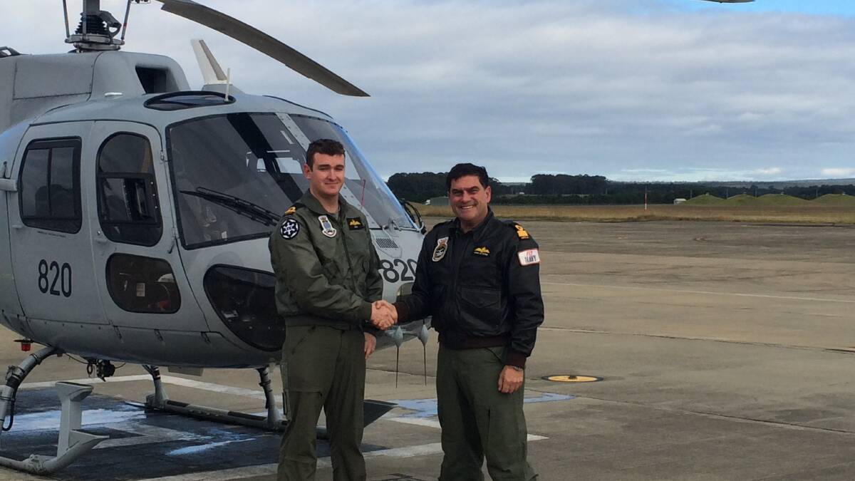 CONGRATULATIONS: Commander of the Fleet Air Arm Commodore Vince Di Pietro (right) and Sub Lieutenant Jarrod Huisman congratulate each other on their impressive milestones while flying a Squirrel helicopter from 723 Squadron at HMAS Albatross.