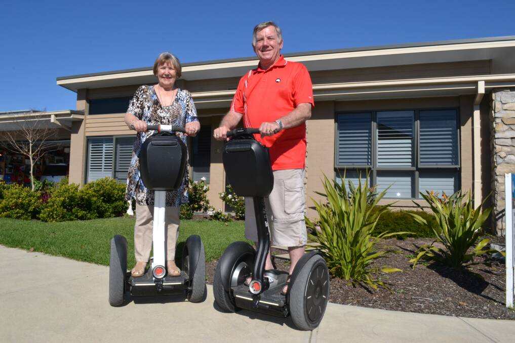HIGHLY MOBILE: Brenda and Peter O’Boyle atop their Segways in front of their home in Coastal Waters Retirement Village.