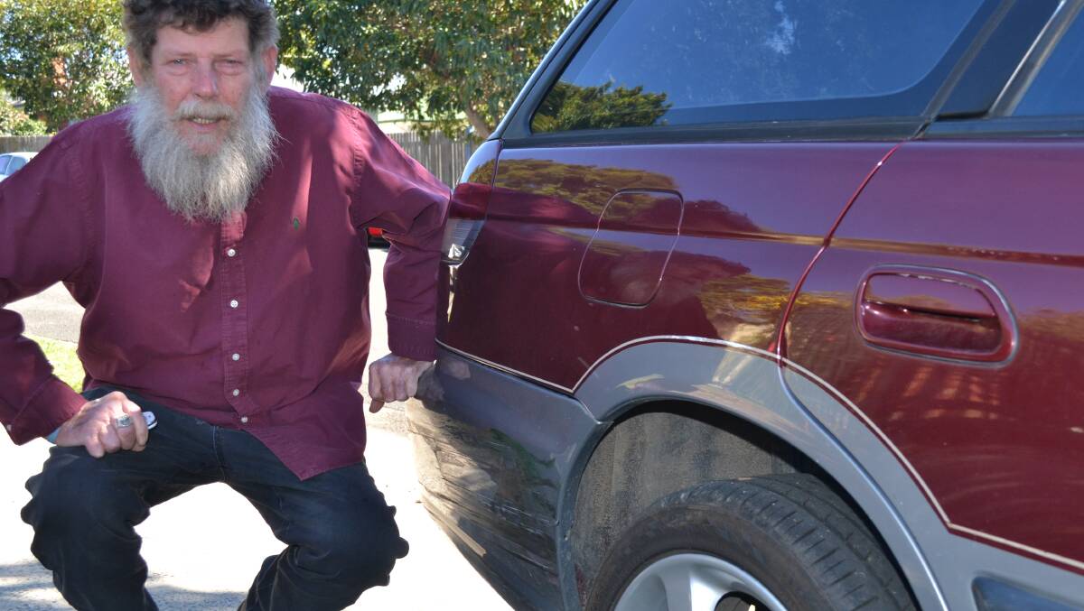 ROUGH RIDE: Bomaderry man Mick Marcal inspects the damage to his car after being caught up in a high speed police chase last Thursday.