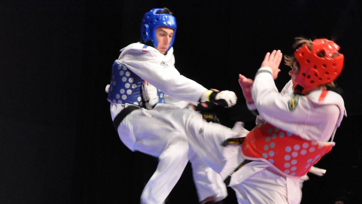 HIGH KICK: Eclipse Taekwondo coach Daniel Smith (right) kicks his opponent mid-air at the 2013 South Coast Open. Photo: NANDO LATTANZIO
