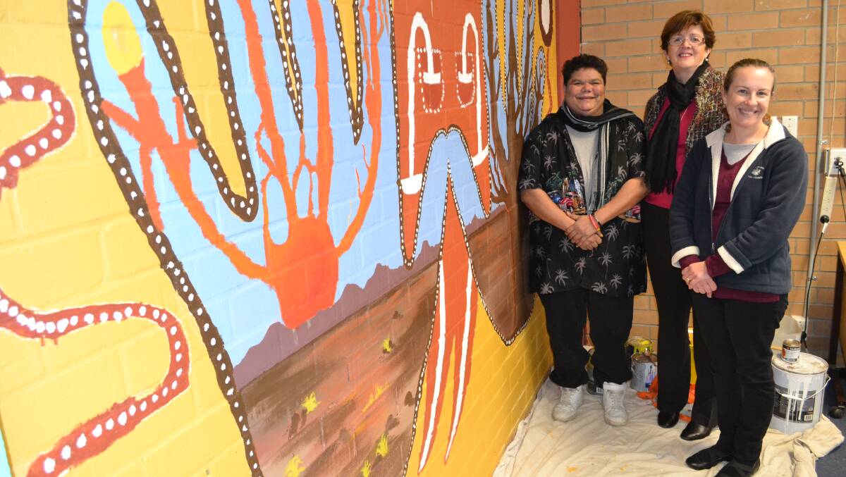 DREAMTIME: Nowra Aboriginal artist Kerrie Williams, Shoalhaven High School deputy principal Kerrie Lindsay and support unit teacher Melinda Brennan with the mural designed by Ms Williams and painted by students.
