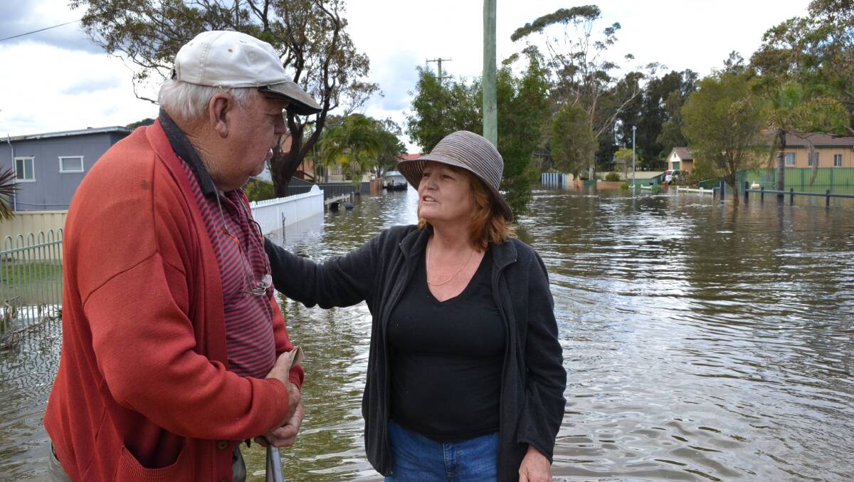 KINDNESS: Sussex Inlet resident Julie Sigsworth comforts Jim Chivers after walking through floodwaters to go to the chemist and get medication for the 77-year-old.