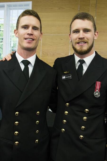 BROTHERS IN ARMS: Sub Lieutenant Mitchell Laughlan (left) celebrates his graduation from New Entry Officer Course 52 at HMAS Creswell with his identical twin brother, Sub Lieutenant Timothy Laughlan