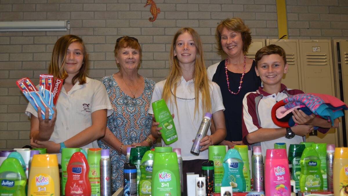 HUGE EFFORT: Shoalhaven Homeless Hub manager Kerri Snowden and family counsellor Veronica Malesevic accept toiletry packs for the hub from Vincentia High students Tiana Bennett, Madeleine Cooper and Hayden Regent.