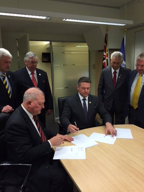 SEALED: Glenn Kolomeitz signs his contract with the NSW RSL at Anzac House in Sydney.