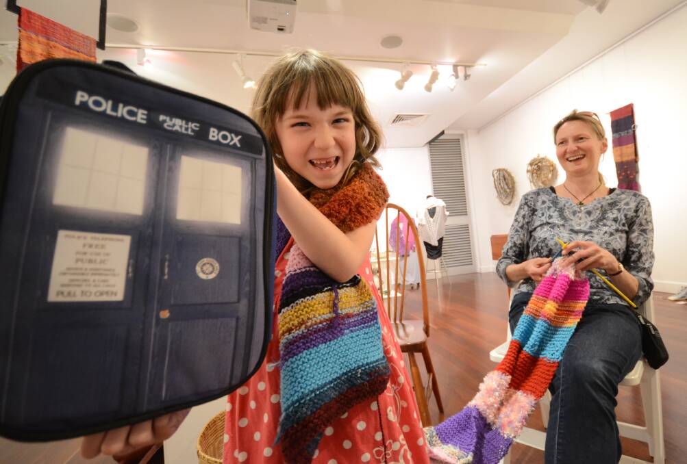 WOOLLY WORK: Lizzy Stiles wears the Doctor Who scarf while her mother Janelle contributes to its length during the Creative Moments exhibition at the Shoalhaven City Arts Centre.