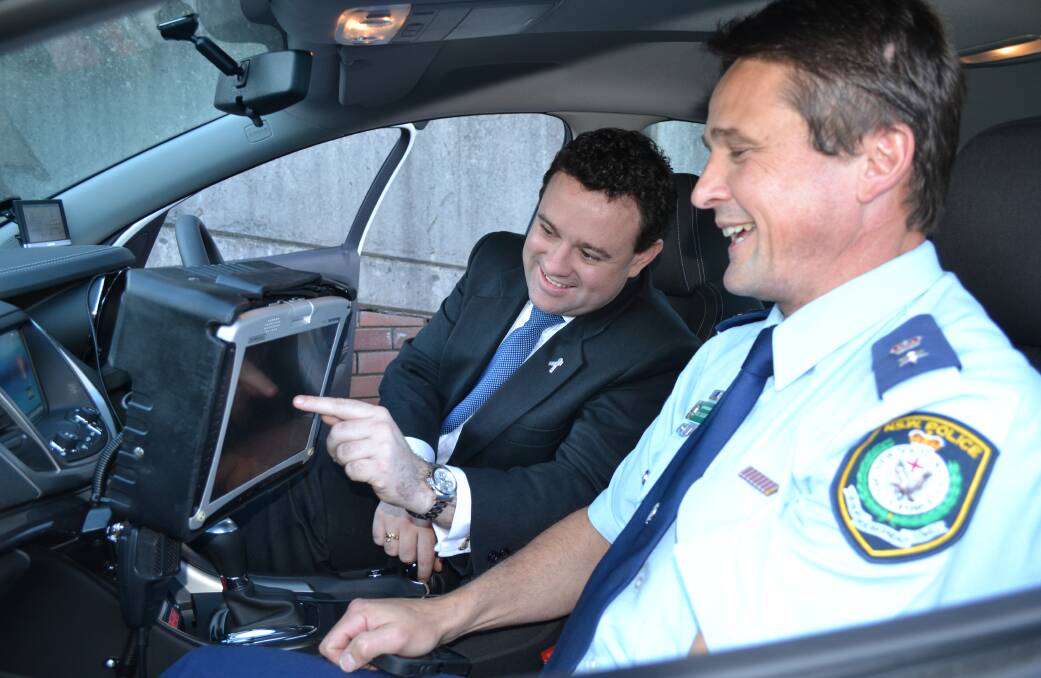 IN THE HOT SEAT: Minister for Police and Emergency Services Stuart Ayres gets a firsthand look inside a police car and at its new equipment with Shoalhaven Local Area Commander, Superintendent Joe Cassar during his visit.