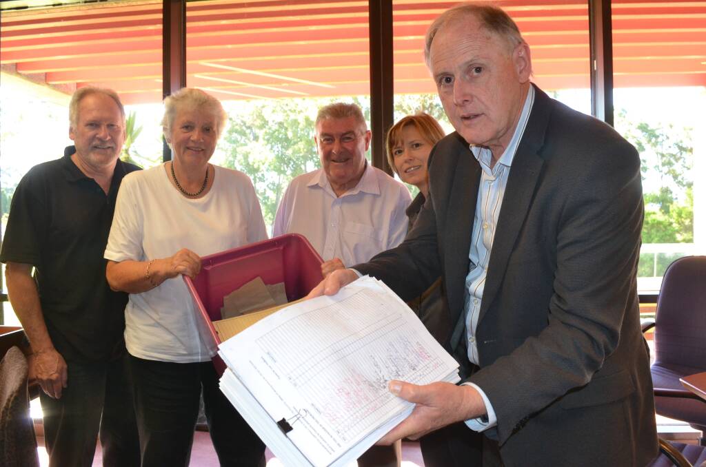 OPPOSITION: 
Don’t Bomb Bomaderry spokesperson Wes Hindmarsh (front), Friendly Grocer North Nowra owner Simon Regnault and Bomaderry Pharmacy owner Rachel Forgan present documents and a petition against the Woolworths development at Bomaderry to Shoalhaven Mayor Joanna Gash and deputy mayor John Wells.