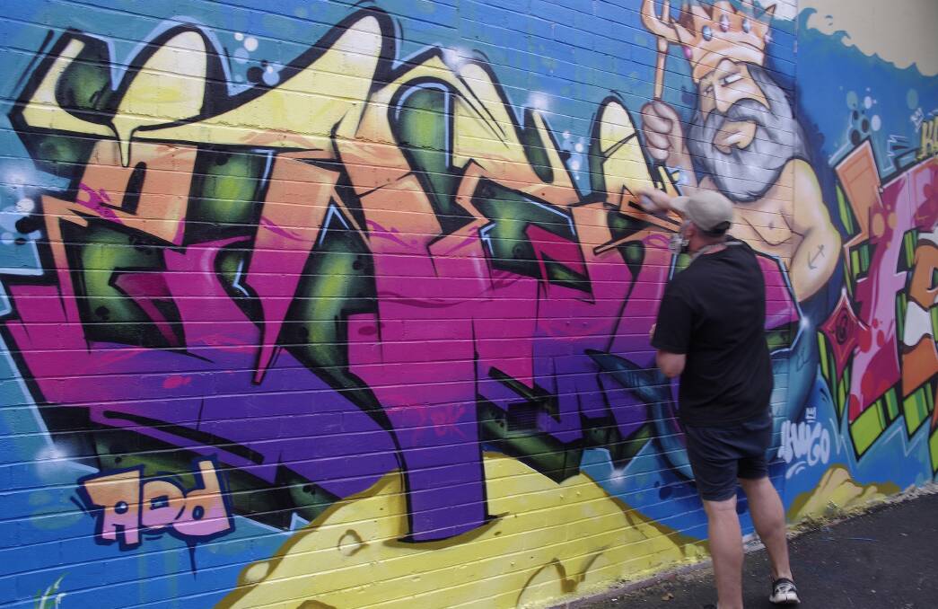 SPLASH: Aerosol artists turned one of Nowra CBD’s forgotten blank walls into an explosion of colour. 	Photo: Geoff Parsons
